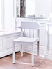 Interior image close up. White dining chair with armrests placed in the corner of a space.