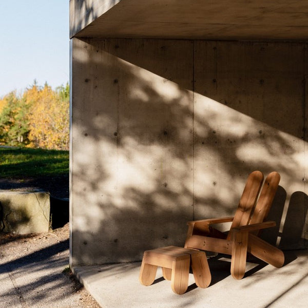 Outdoor furniture made from heat treated pine. Light and shadow play. A footrest and a lounge chair.