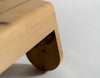 A close up of a footrest made from heat treated pine. Soft shapes. White background.