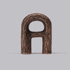 Norwegian design. A curvy shaped bottle opener from solid bronz. Light grey background.