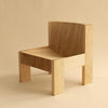 005 Lounge chair by Max Lamb for Vaarnii í Helsinki. Studio image with beighe background. Chair seen from an ancle.