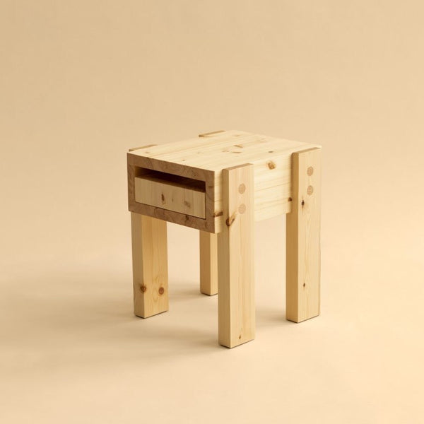 003 Stillts side table by Vaarnii. Made from pine. Studio image with beige background.