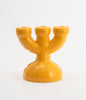 Super cute, three spoke candlebra with soft shapes in yellow ceramics. White background. No candles.