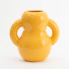 A beautiful and curvy, yellow vase made from glossy ceramics. White background.