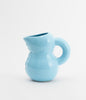 Ceramic water jug. Glossy ceramic. Baby blue colour. White background.