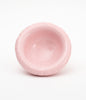 A round, pale pink ceramic bowl on a white background. Soft shapes. The bowl is empty.