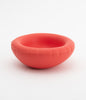 cute little ceramic bowl in red on a white background. The bowl is empty.
