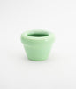 A mint green flower pot on a white background. The flower pot is made from ceramics.