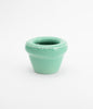 Cute and tiny flower pot. Pastel green and glossy ceramic. The planter is empty. White background.