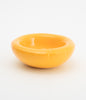 A round and yellow ceramic bowl on a white background. Soft shapes. Almost cartoonish. The bowl is empty.
