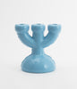 A beautiful and cartoonish, three spoke candlebra in baby blue ceramic. White background. No candles.