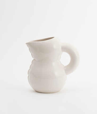 A beautiful jug in glossy white cearmic. White background.