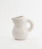A beautiful jug in glossy white cearmic. White background.