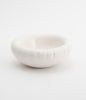 A round, white ceramic bowl on a white background. The bowl is empty.