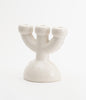 A super cute, soft shaped candlebra in white ceramic on a white background.