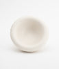 A small and pretty little ceramic bowl in white on a white background. The bowl is empty.