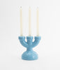 Adorable, three spoke candlebra in baby blue ceramic. White candles. White background.