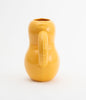 A side view of a curvy vase made from mat, yellow ceramics. White background.