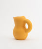 A super cute and soft shaped jug made from mat, yellow ceramic. White background.