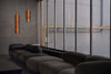 Modern interior with a dark gray sofa and two large glass pendant lights.