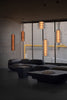 Modern living room with dark furniture and pendant lights.