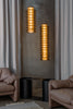 Two cylindrical, glass pendant lights in a modern living room setting with neutral tones.