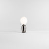 Table lamp in platinum with opaque glass shade. White background.