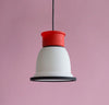 A pretty little pendant light in red, white and black by the famous British designer George Sowden. Pink background. The light is switched off.