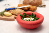 A cute, red ceramic bowl filled with yoghurt sauce.
