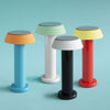 Four, cute little table lamps of the same kind but in different colour combinations. Turquoise background.
