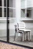 Beautiful black and white stacked garden chairs. Seen through a window.