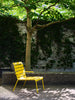 A gorgeous and comfortable outdoor lounge chairs with armrests in a garden on a sunny summer day.