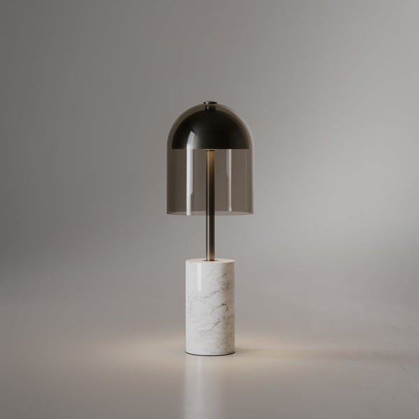 Dásamlegur borðlampi frá Venicem. Undirstaða úr hvítum marmara. Dökk brennt brass. Reyklitaður glerskermur. Ljós grár bakgrunnur. Kveikt er á lampanum.