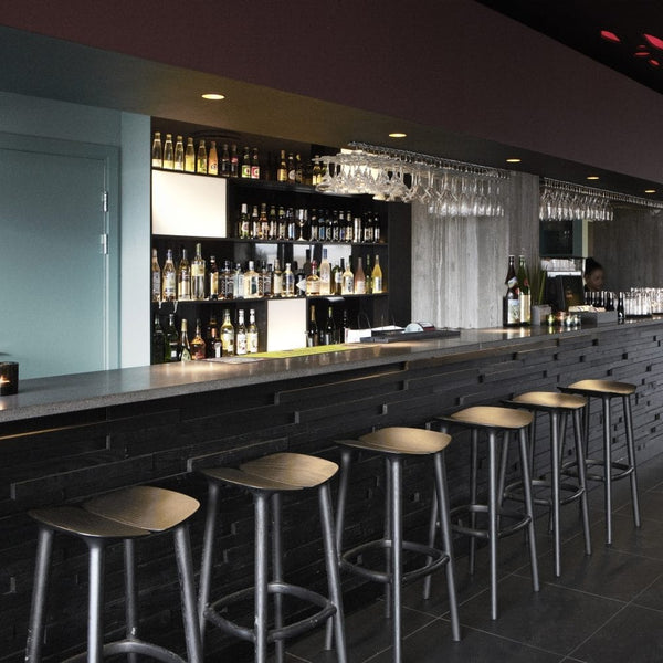 Svartir barstólar upp við svartan bar.