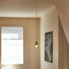 Pendant light hanging in a room with a window and wall art.
