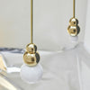 Gold and white spherical pendant on a blurred background