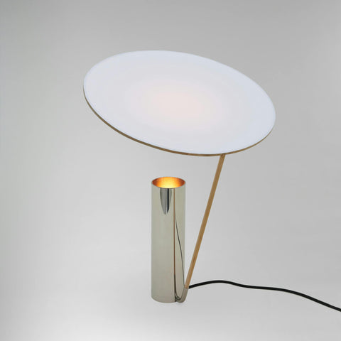 Sérlega fágaður borðlampi frá Michael Anastassiades úr fægðu nickel. Ljós bakgrunnur. Kveikt er á lampanum.