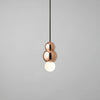 Copper pendant light with a white bulb on a gray background