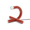 Modern red table lamp with a white bulb on a white background
