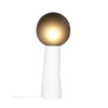 A white ceramic floor lamp on a white background. Handmade, smokey grey glass diffuser. The lamp is lit.