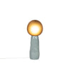 Blue grey ceramic floor lamp with handmade glass diffuser in smokey grey. White background. The light is on.