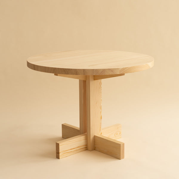 001 Dining Table in round version. Studio image with beige background. Table is made from sustainably grown pine