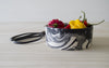 Beautifully designed black and white bowl. Close up. Red and yellow paprikas and peppers in the bowl. Black scissors on the table next to the bowl.