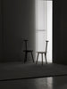Two dining chairs of the same kind in the middle of the photo. A play with light and shadows.