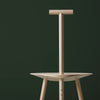 Product photo. A light wooden dining chair on a dark green background.
